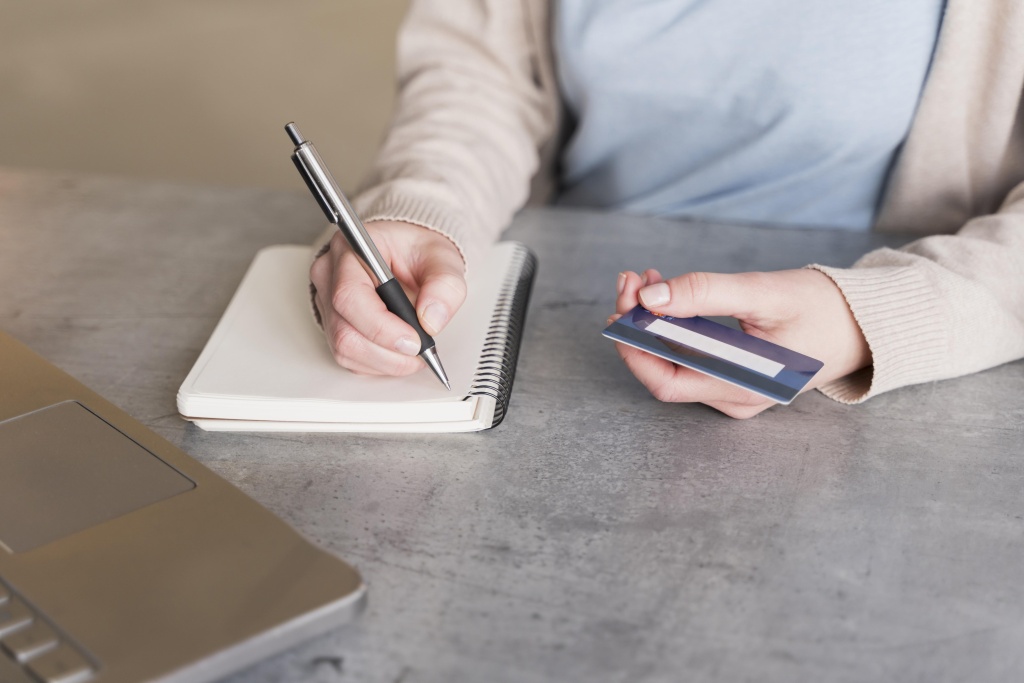 high-angle-woman-writing-down-notebook-while-holding-credit-card.jpg блокнот