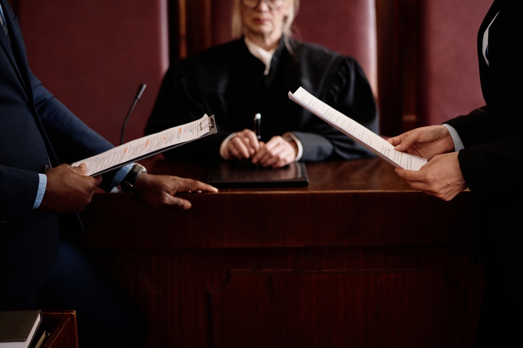 closeup-prosecution-defense-sides-with-juridical-documents-standing-opposite-each-other.jpg судья